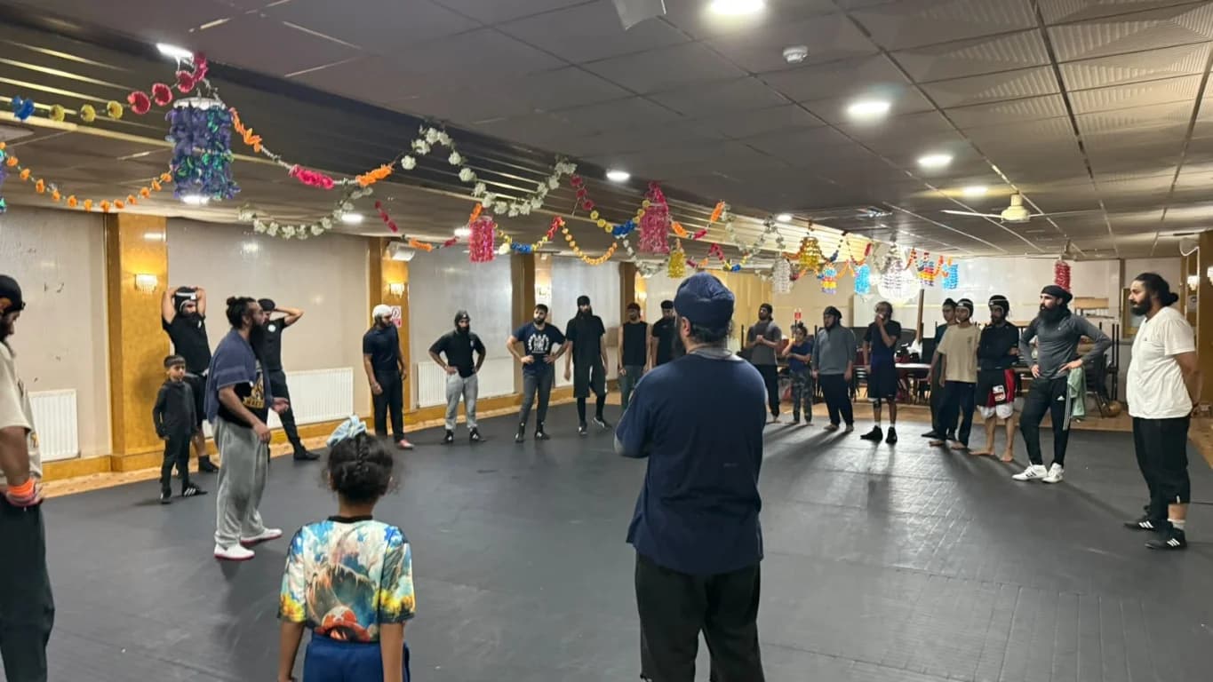Academy participants gathered around the training mats