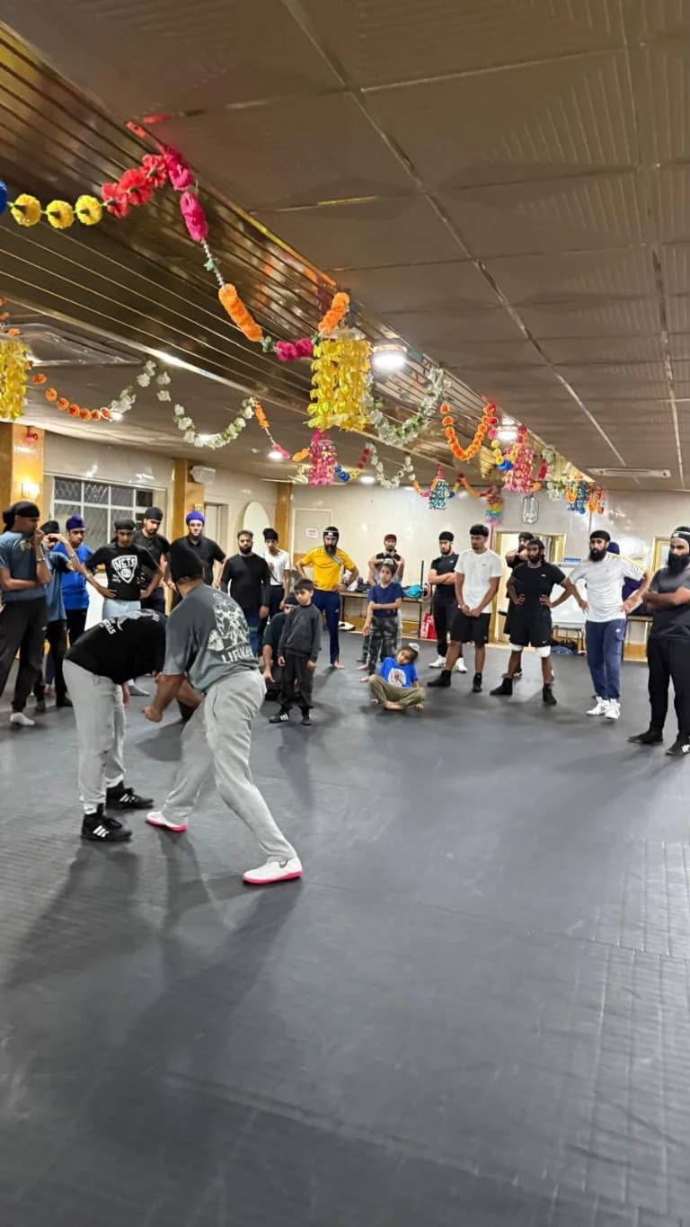 Wrestlers demonstrating a standing technique to the class